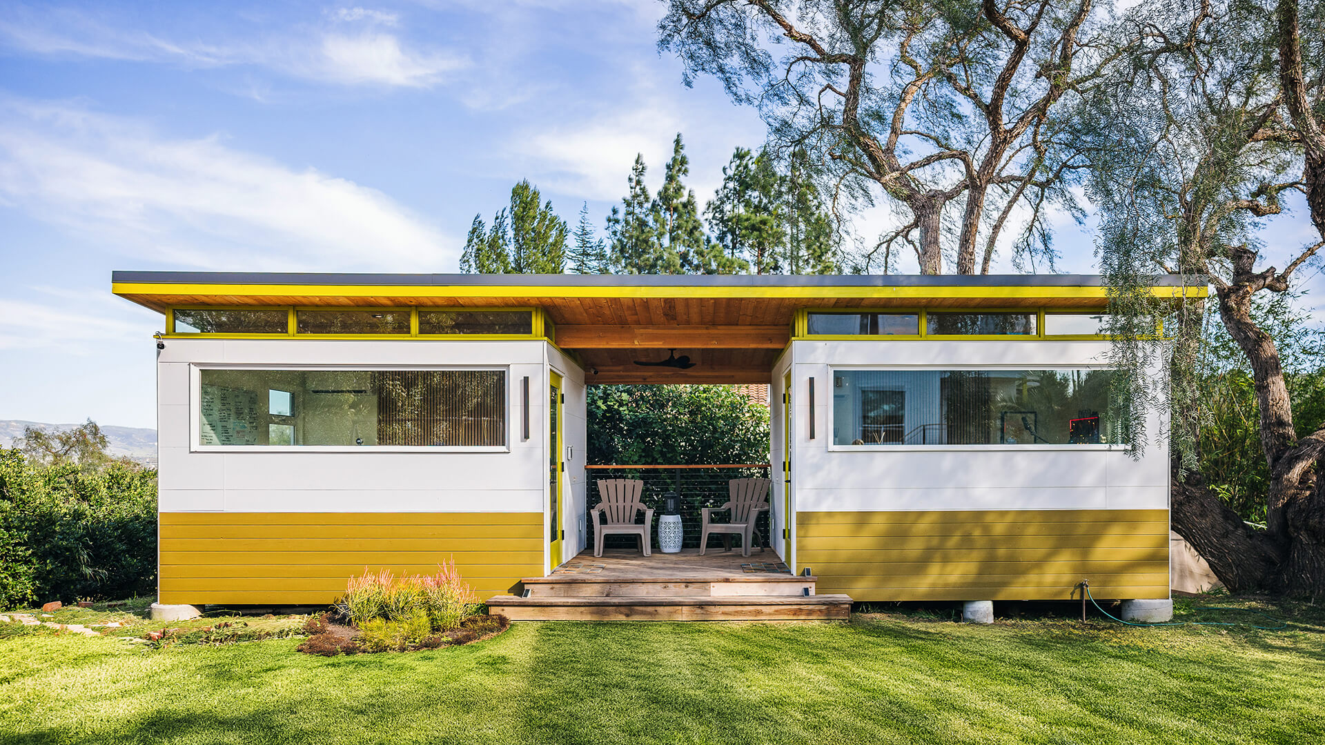 Modern prefab shed with covered patio and lawn